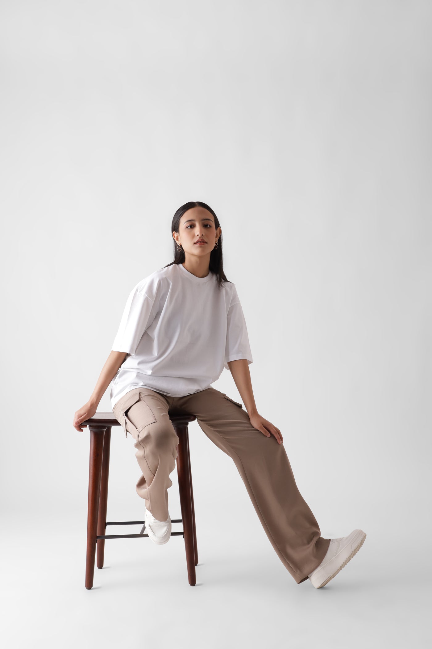 Classic oversized white tshirt for women - sitting on a chair front view full - unbound crew