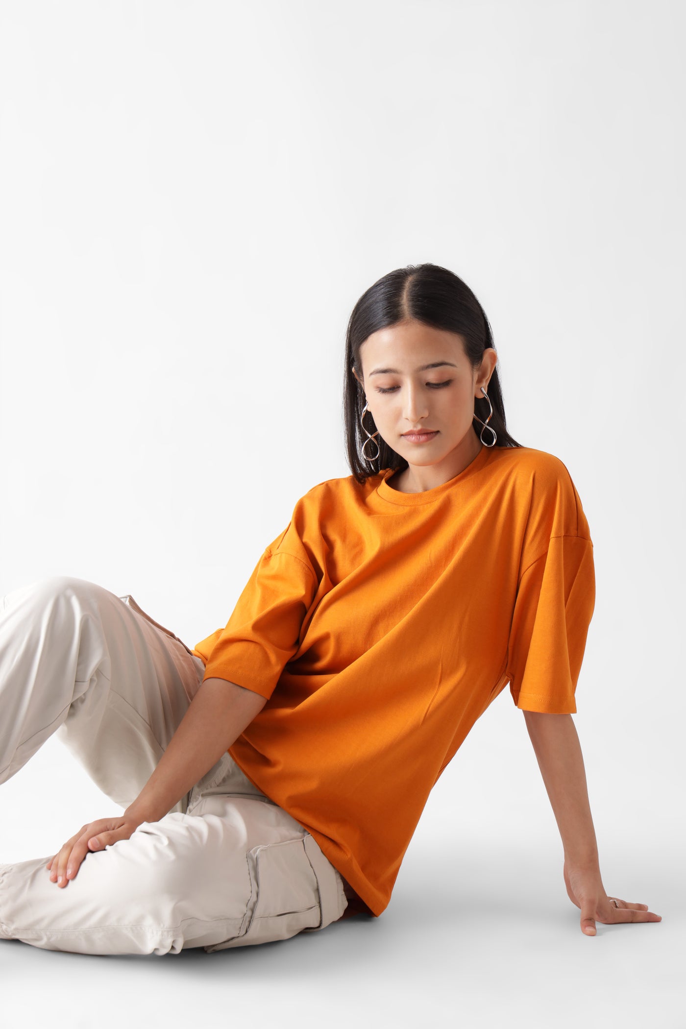 Classic oversized orange tshirt for women - sitting on the floor - unbound crew