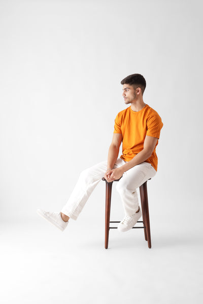 Classic half sleeve orange tshirt for men - sitting on a chair - unbound crew