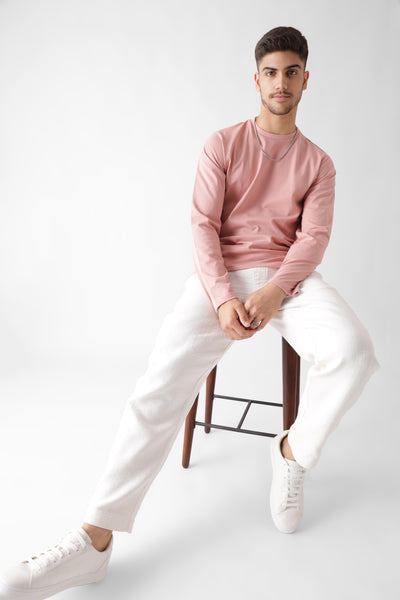 Classic long sleeve dust pink tshirt for men - sitting on a chair - unbound crew