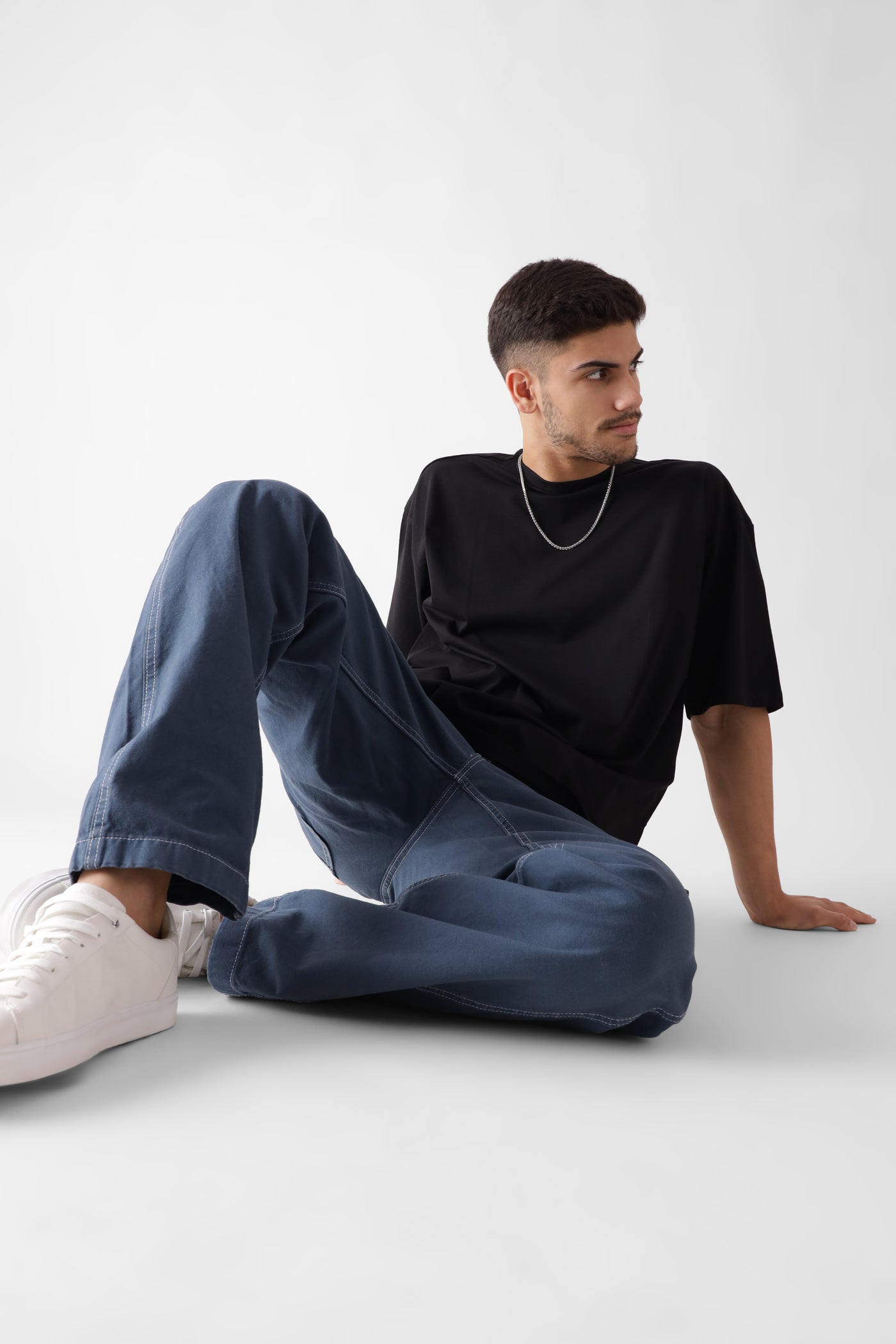 Classic oversized black tshirt for men - sitting on the floor - unbound crew